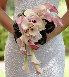 a woman in a wedding dress holding a bridal bouquet with pink and white flowers