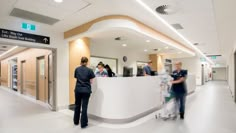 people are standing at the front desk of a hospital