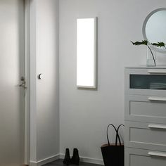 an empty room with a mirror and white walls