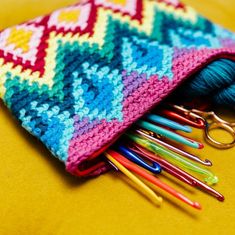 colorful crocheted pouch with scissors and knitting needles