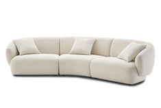 the curved sofa has four pillows on it