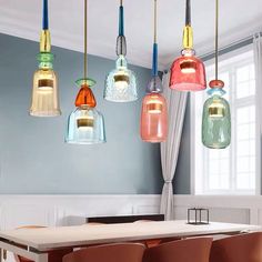 a dining room table and chairs with colorful lights hanging from it's ceiling above them