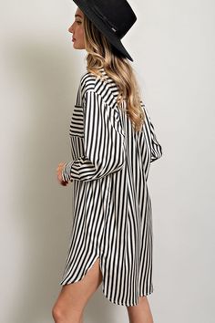 Stripe printed button down shirt dress featuring a collared neckline, one chest pocket, a high-low design, buttoned cuffs, two side slits, and a pleat in the back for added detail. Measurements: Bust: small 46", medium 48", large 50" Front Length: small 35", medium 36", large 37" Back length: small 37", medium 38", large 39" Long Sleeve Shirt Dress With Striped Collar For Work, Classic Striped Long Sleeve Shirt Dress, Spring Shirt Dress With Striped Collar For Work, Spring Workwear Shirt Dress With Striped Collar, Fall Daywear Shirt Dress With Cuffed Sleeves, Spring Chic Shirt Dress With Rolled Sleeves, Chic Spring Shirt Dress With Rolled Sleeves, Button-up Shirt Dress With Striped Collar For Work, Chic Collared Midi Dress For Day Out