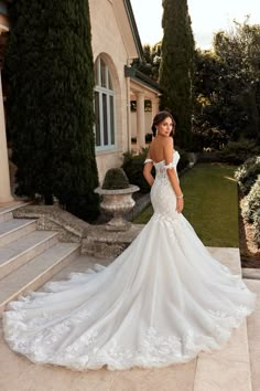 a woman in a wedding dress standing on steps