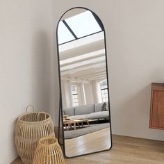 a large mirror sitting on top of a wooden floor next to a basket filled with furniture