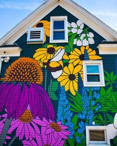 a house painted with flowers and bees on the front wall is shown in full color