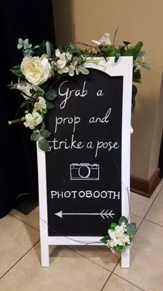 a chalkboard sign with flowers and greenery on it that says grab a prop and strike a pose