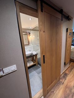 an open door leading to a bathroom with wood floors