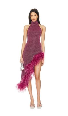 The Oseree Lumiere Plumage Turtleneck Dress features a turtleneck, an asymmetrical hemline, and a feather trim. It is made of 64% polyamide, 36% metallic fiber, 100% ostrich feathers, and 92% polyamide, 8% elastane. The dress is fully lined and has a pull-on styling with a button closure at the neck. The dress is made in Italy and is hand washable.