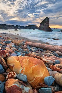 the beach is covered in colorful rocks and water