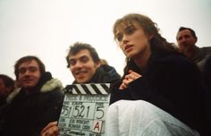 a group of people standing next to each other holding a movie clapper in front of them