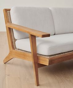 a white couch sitting on top of a hard wood floor next to a wooden table