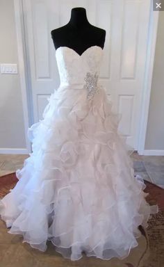 a white wedding dress on display in front of a door