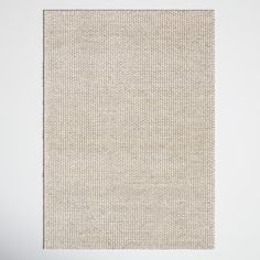 a white rug with small squares on the bottom and one square in the middle, against a wall