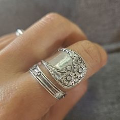 a close up of a person's hand wearing a ring with flowers on it