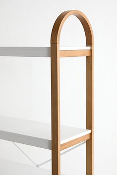 a white shelf with a wooden arch on it