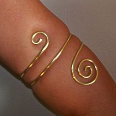 This armlet has been created using thick 12 gauge brass. This armlet wraps twice around the arm and is adorned with a small swirl on the top and a larger swirl on the bottom. ♥These are available in brass, bronze, copper and German silver. Please note that German silver contains nickel and contains no silver, but is lead free. Please Note: When measuring your lower arm for this piece...be sure the size you choose is the thickest part of the arm it will sit, as this piece is slightly tapered. if Handmade Flexible Gold Bracelet, Gold Handmade Flexible Bracelet, Wire Wrapped Gold Bracelets For Festival, Gold Wire Wrapped Bracelets For Festivals, Gold Wire Wrapped Bracelet For Festival, Upper Arm Jewelry, Armlet Gold, Arm Cuff Jewelry, Upper Arm Bracelet