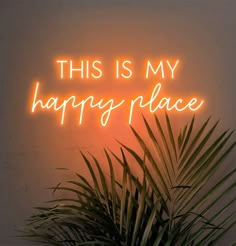 a neon sign that says, this is my happy place on the wall next to a potted plant