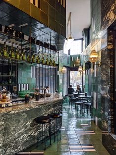 an empty bar with stools and bottles on the shelves