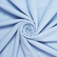 a close up shot of a light blue fabric that has been folded in the shape of a spiral