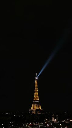 the eiffel tower lit up at night with its bright lights shining on it