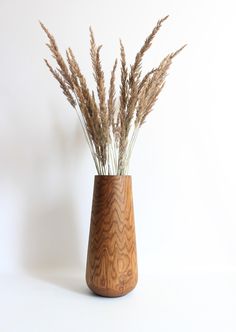 some brown grass in a wooden vase on a white background