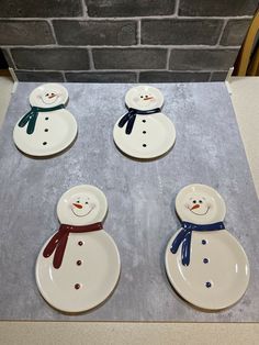 four snowman plates sitting on top of a counter