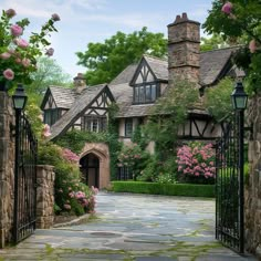 the entrance to an old style house with roses growing on it's walls and gate