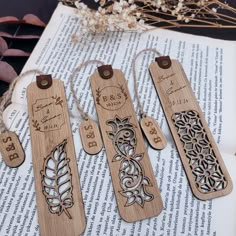 three wooden bookmarks are sitting on top of an open book