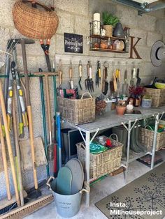 a room filled with lots of different types of gardening tools and plants in baskets on the wall