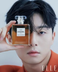 a man holding up a bottle of chanel perfume