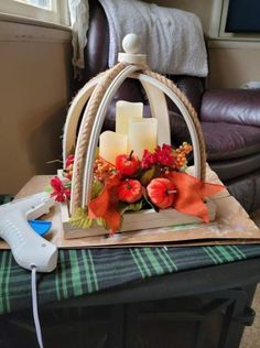 a birdcage with candles and flowers in it sitting on top of a table