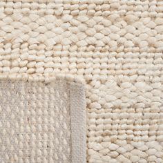 a close up view of a white rug with some sort of woven material on it