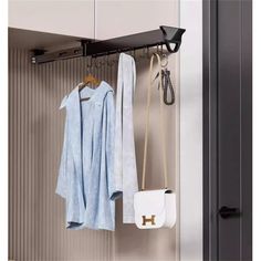 a coat rack with two coats hanging from it and a purse on the other side