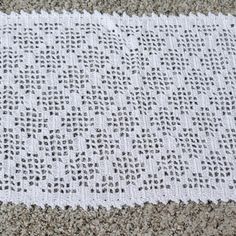 a white crocheted blanket laying on top of a carpet next to a pair of scissors