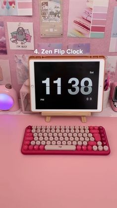 a pink desk with a clock and keyboard on it