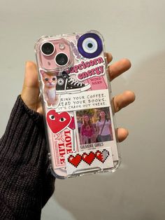 a person holding up a cell phone case with pictures and stickers on the back