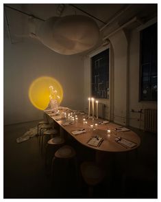 a long table with candles on it in front of a large window and some chairs