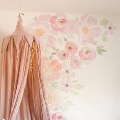 a canopy bed in a girls room with flowers painted on the wall