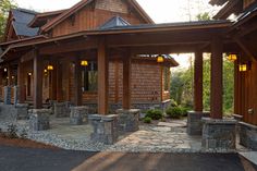 a wooden house with stone steps leading to the front door and covered porch area, surrounded by trees