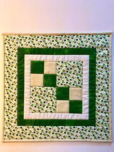 a green and white quilted wall hanging