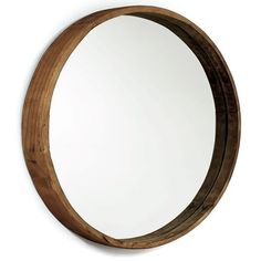 a round wooden mirror hanging on the wall