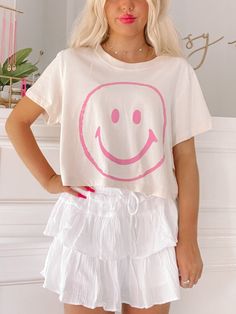 Add a smile to your wardrobe with the Simply Smiley Tee from Sassy Shortcake - This neutral cropped tee puts a pink smiley face front and center. She is paired here with our flirtatious white linen skirt. fit: true to size, model wearing a size small. care: hand wash cold Preppy Back To School Outfits, Cute Preppy Clothes, Preppy Shirts, Sassy Shortcake, Pink Smiley Face, White Linen Skirt, Pink Smiley, Preppy Shirt, Preppy Fits