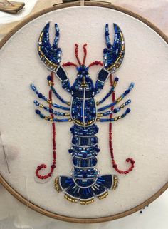 a blue lobster with red, white and blue beading on it's body