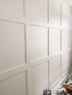 a man is painting the walls in his house with white paint and wood trimmings