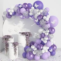 purple and white balloons are arranged in the shape of a letter