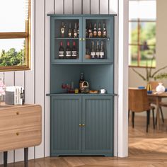 a blue cabinet filled with lots of bottles next to a dining room table and chairs