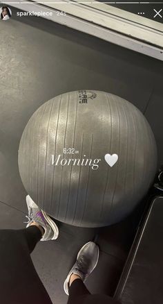 a person standing next to an exercise ball on top of a conveyor belt with the words morning written on it