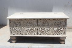 an old stone box sitting on top of a tile floor in front of a white wall