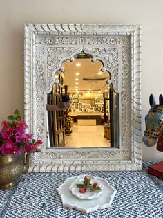 a decorative mirror sitting on top of a table